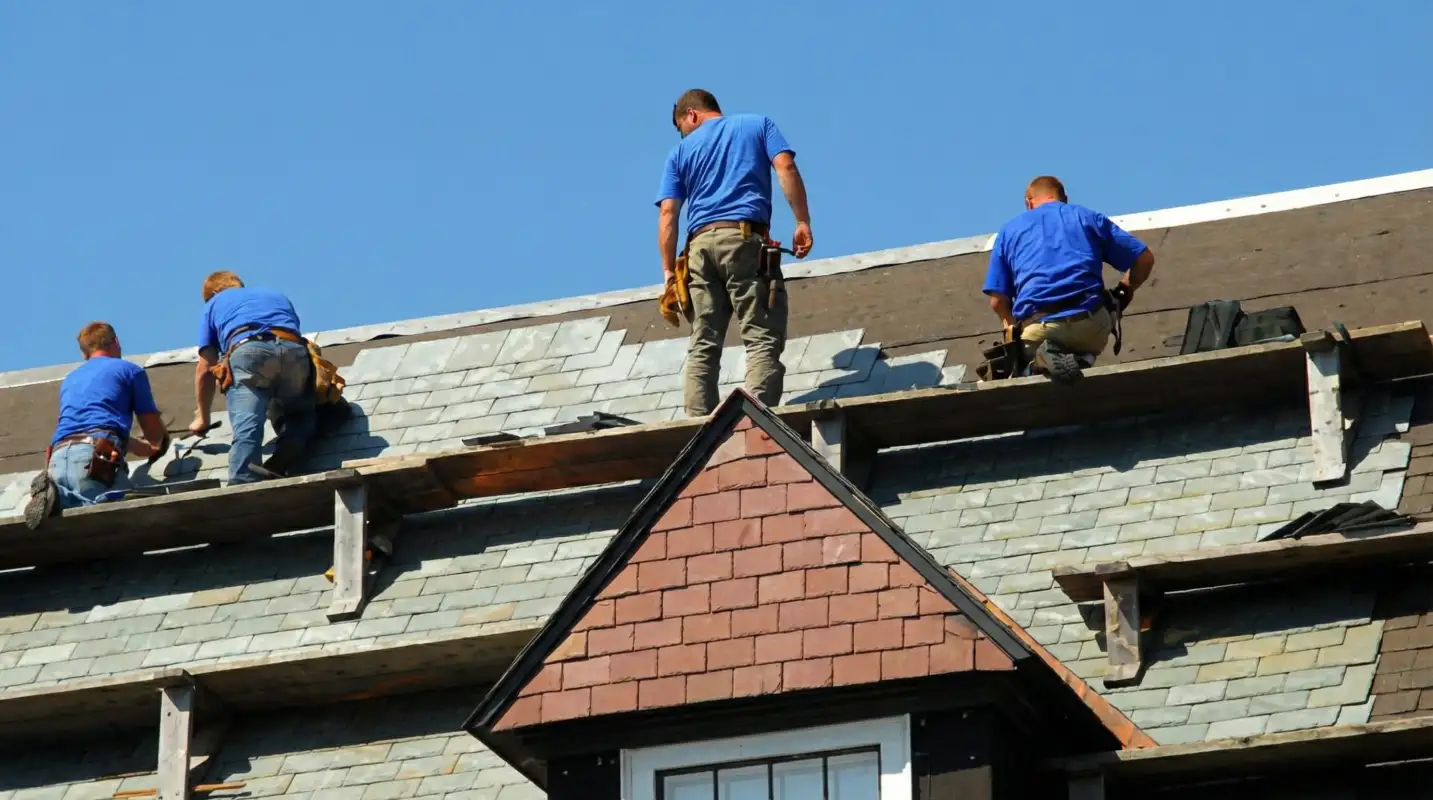 Roof replacement in progress with a team of professional contractors installing new shingles on a residential home in Buffalo, NY